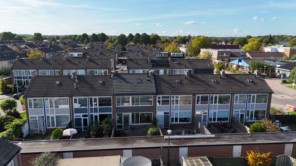 Een foto van de achterzijde van een blok woningen aan de Schoutstraat in Woudenberg
